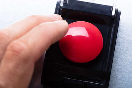 Close-up Of Person's Hand Emergency Bell On Table