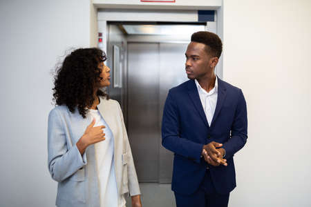Young African Businesspeople Having Conversation In Elevatorの写真素材