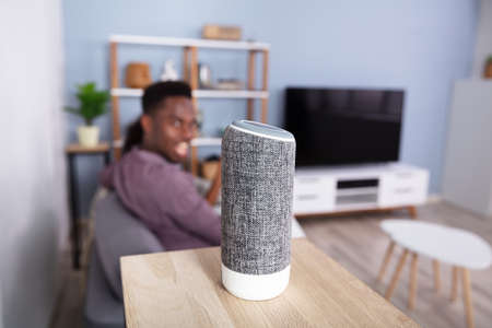 Close-up Of Wireless Speaker In Front Of African Couple
