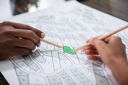 Hands Holding Pencils Over Cadastre Map Stock Photoの写真素材
