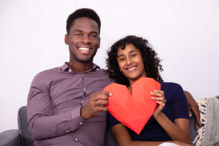Romantic Couple Holding A Red Heart At Homeの写真素材