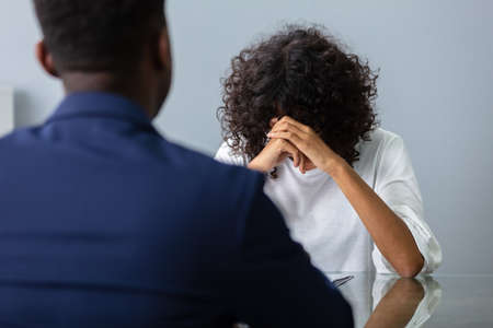 Stressed Young Business Woman Holding Her Head At Interview In Officeの写真素材