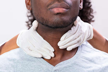 Doctor Performing Physical Exam Palpation Of The Thyroid Glandの写真素材