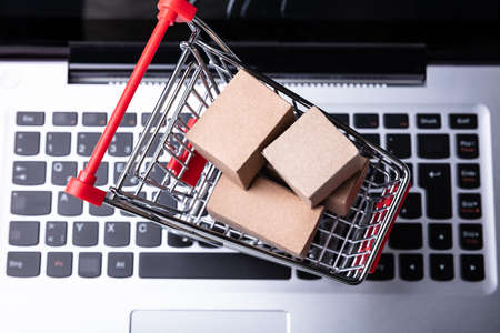 An Elevated View Of Paper Boxes In A Shopping Cart On A Laptop Keyboardの写真素材