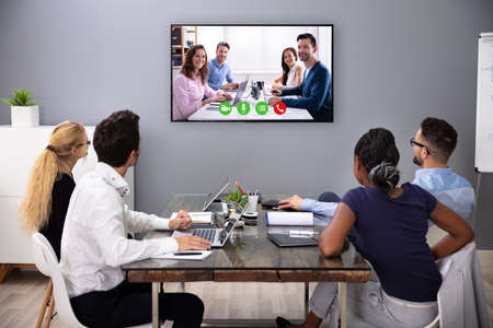 Businesspeople Sitting In A Conference Room Looking At Computer Screenの写真素材