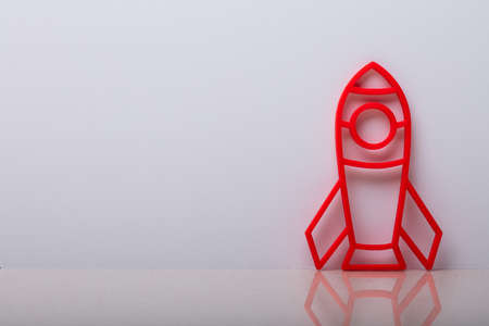 Close-up Of A Rocket Symbol Leaning On White Wall