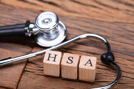 HSA Health Savings Account Wooden Blocks Near Stethoscope On Wooden Tableの写真素材