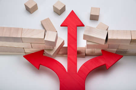 Arrow Breaking Through Wall Made Of Wooden Blocks On White Backgroundの写真素材