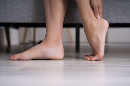 Woman Feeling Achilles Heel Pain At Homeの写真素材
