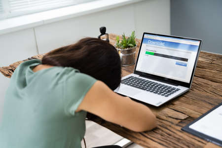 Woman Fell Asleep White Waiting For Slow Download On Laptopの写真素材