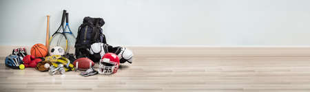 Different Type Of Sports Equipment On Wooden Desk Against White Wallの写真素材