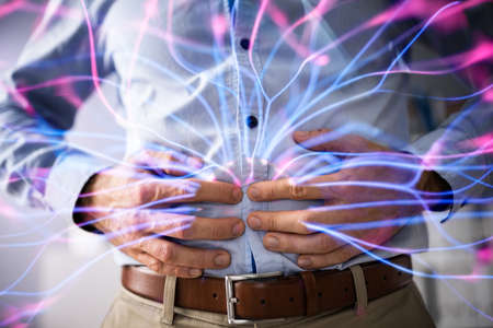 Midsection Of Businessman Suffering From Stomach Ache Against White Backgroundの写真素材