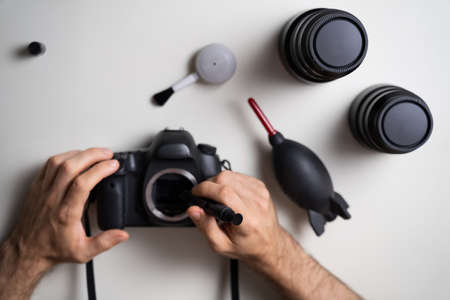 High Angle View Of Man Cleaning DSLR Camera Sensorの写真素材