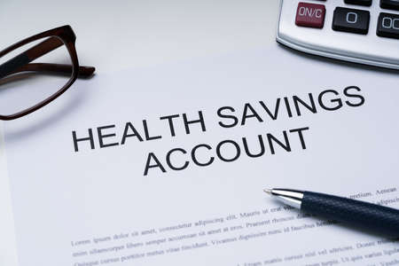 Health Savings Account Form With Spectacles, Pen And Calculator Over Deskの写真素材
