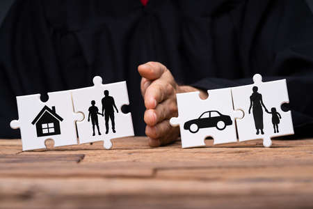 Jigsaw Puzzles Showing Separation Of Family With House And Car Divided By Person's Handの写真素材