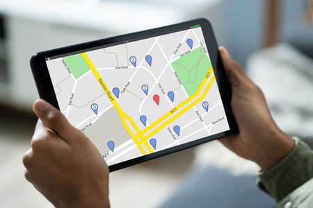Close-up Of A Person Sitting In A Car Using GPS Service On Digital Tablet