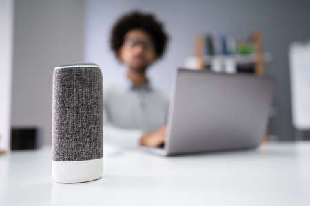 Close-up Of Young Businessman Speaking On Wireless Speaker At Workplaceの写真素材