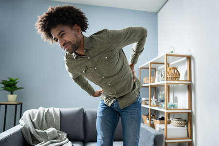 Man Having Backache While Standing At Home