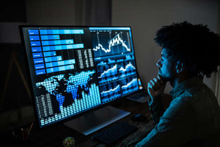 Close-up Of A Businesswoman's Hand Analyzing Graph On Computer At Workplace