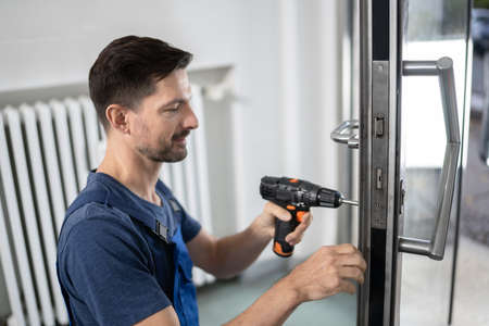 Portrait Young Male Carpenter Repairing Door Lock