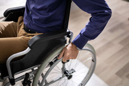 Close-up Of Businessman Sitting On Wheelchair In Office
