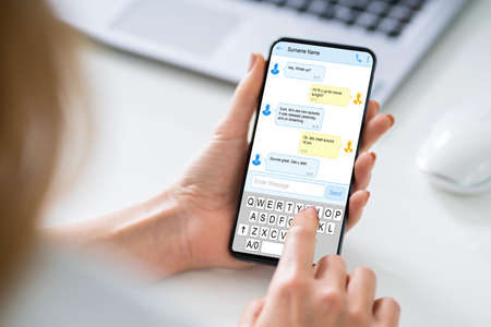 Close-up Of A Person's Hand Sending Text Message From Smartphone