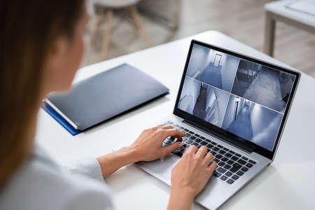 Close-up Of A Businesswoman Monitoring The CCTV Footage Of Office On Laptopの写真素材
