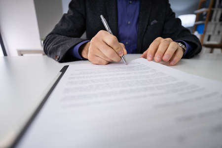 Close-up Photo Of An Businessperson Signing Contractの写真素材