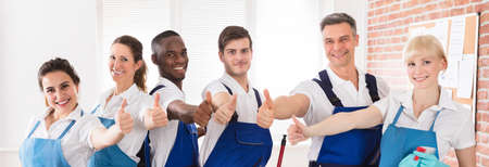 Happy Diverse Cleaners In The Office Showing Thumb Up Signの写真素材