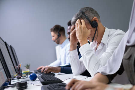 Mature Depressed Businessman Sitting At Office Desk