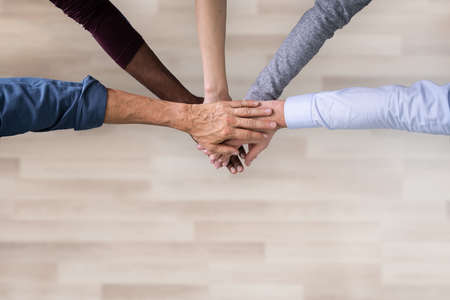 Close-up Of Many Hands Lying On Top Of Each Other