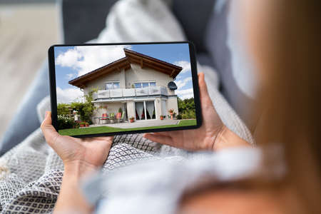Young Woman Selecting New House On Digital Tabletの写真素材