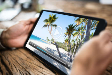 Cropped Image Of Man Watching Movie On Digital Tablet At Homeの写真素材