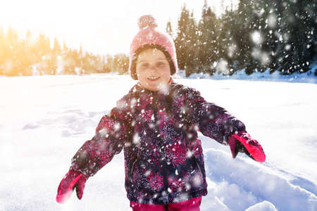 Joyful Adorable Girl Walking With Woolly Hat On Snowy Landscapeの写真素材