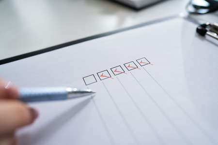 Cropped Image Of Businesswoman Writing On Checklistの写真素材