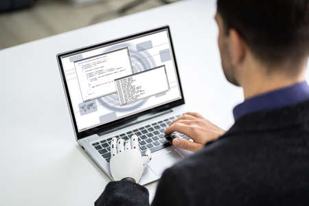 Man With Prosthetic Hand Working On Laptop. Artificial Limb