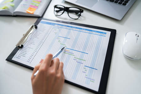 Close-up Of A Businesswoman With Pen Working On Gantt Chartの写真素材