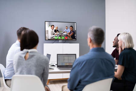 Group Of Businesspeople Having Video Conference In Boardroomの写真素材