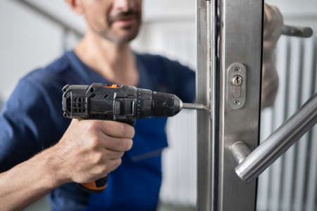 Portrait Young Male Carpenter Repairing Door Lock