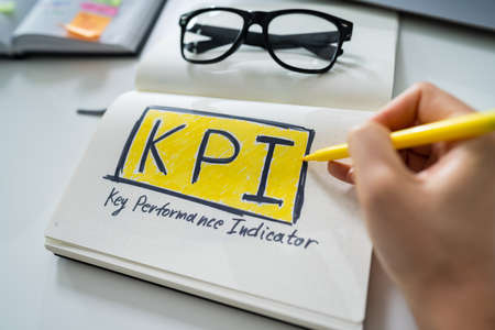 Close-up Of A Businessperson's Hand Drawing Key Performance Indicator Concept On Notebookの写真素材