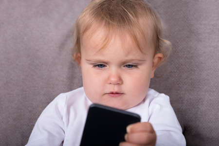 Little Girl With Mobile Phone At Home