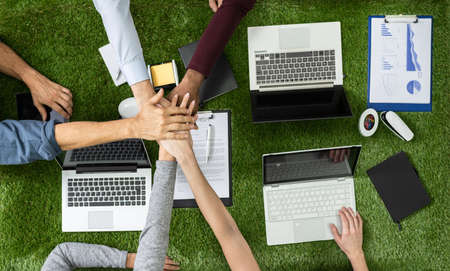 Overhead View Of Businesspeople's Stacking Hand On Above Grass