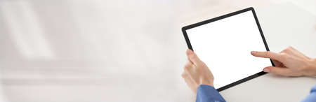 Cropped Image Of Businesswoman Using Digital Tablet At Desk In Officeの写真素材