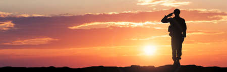 Silhouette Of A Soldier Saluting During Sunsetの写真素材