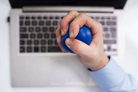 Close-up Of Businessman Holding Stress Ball In Handの写真素材