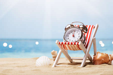 Alarm Clock On Deck Chair On Sunny Tropical Beach