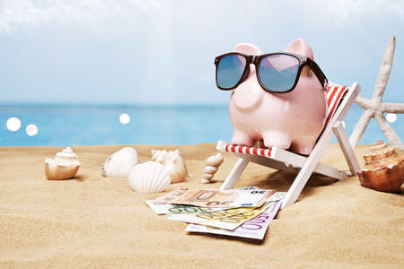 Piggybank With Money And Sunglasses On Beachの写真素材