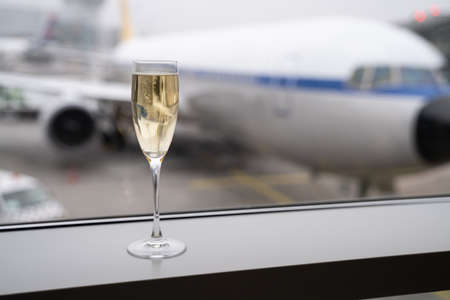 Champagne Glass In Airport Before Boarding Airplane Flightの写真素材