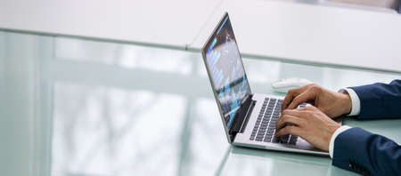 Mid Adult Businessman Working At Desk In Office