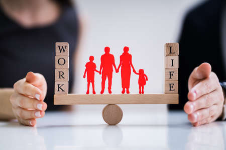 Happy Couple Protecting Balance Between Work And Life With Family Paper Cut Out On Seesaw